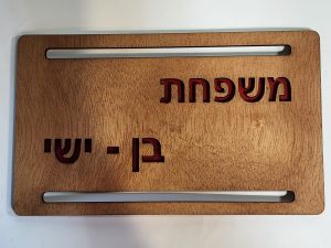 שלט דלת בעבודת יד מעץ בשני צבעים עם טקסט גדול וברור, קל להתקנה באמצעות דבק דו-צדדי.